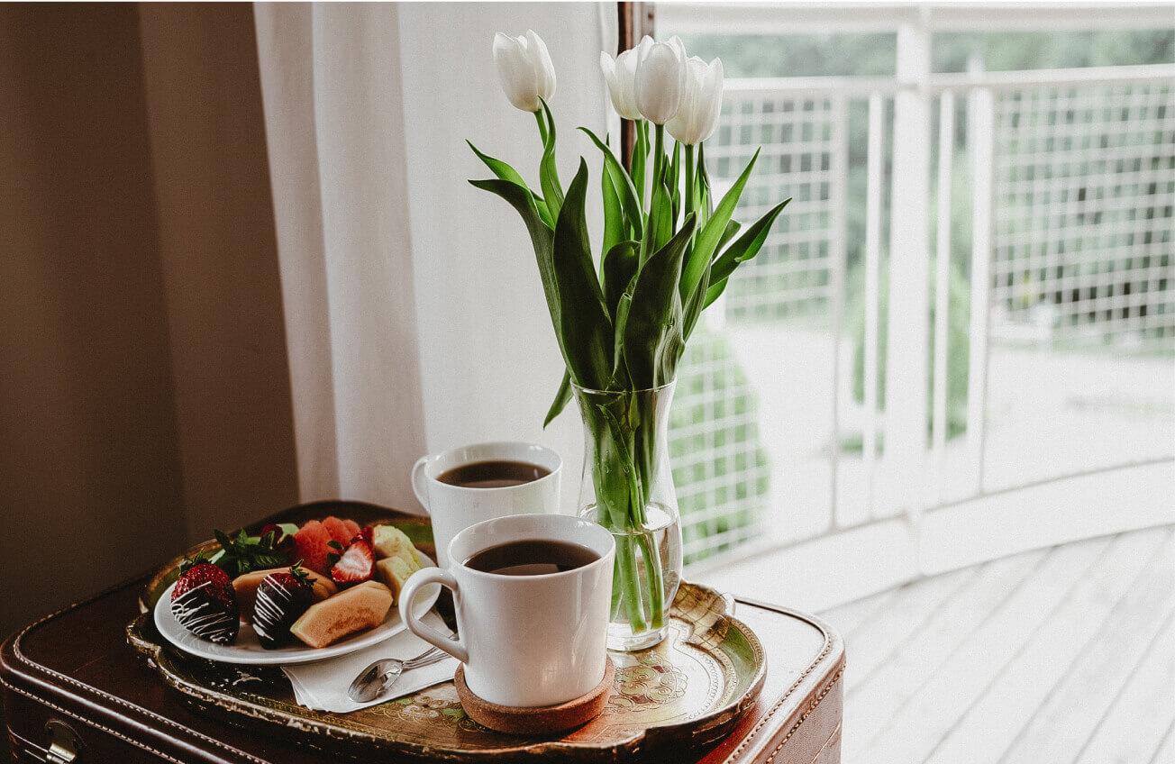 A tray of fruit, coffee, and a vase with tulips at The Kent Motel